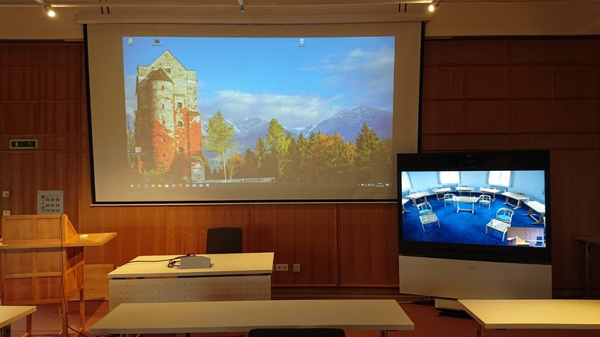 Possibility to connect the Blue Seminar Room with the lecture hall via video conference. The presentation is done via beamer. On the monitor you can see the participants from the Blue Seminar Room... Possibility to connect the Blue Seminar Room with the lecture hall via video conference. The presentation is done via beamer. On the monitor you can see the participants from the Blue Seminar Room...
